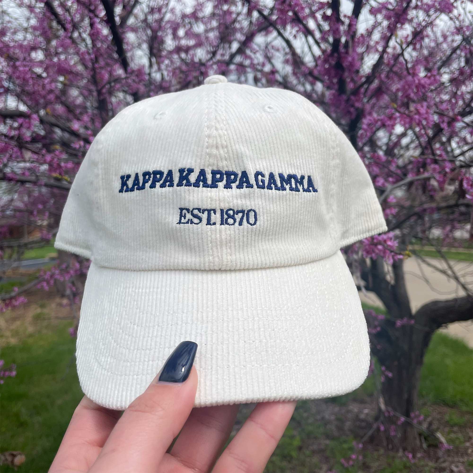 a hand holding a white hat with the words kapakapapagaama