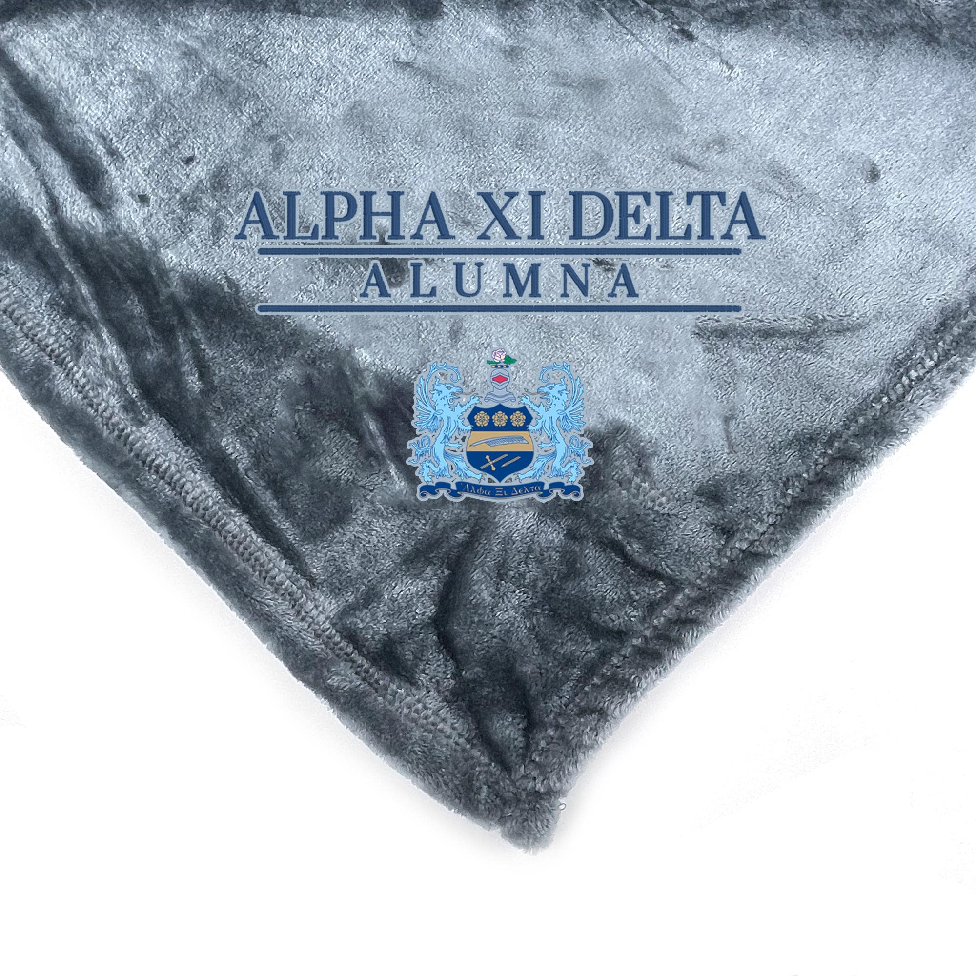 a gray blanket with the text "ALPHA XI DELTA ALUMNA" and a crest or emblem on it.