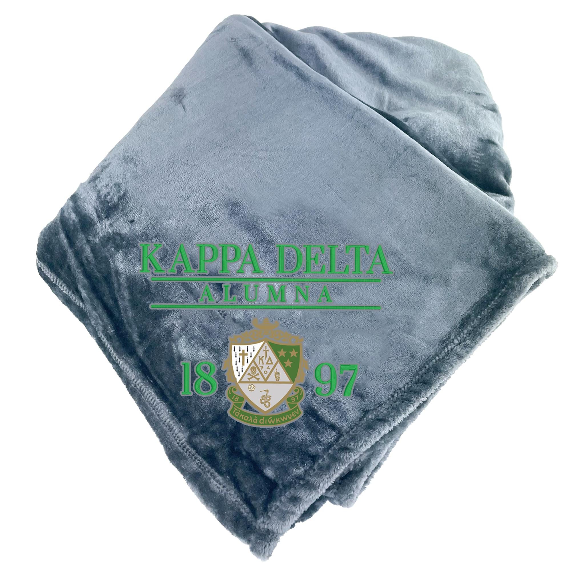 A gray fleece blanket with the text "KAPPAD DELTA ALUMNA" and "1897" printed on it, along with a crest design.
