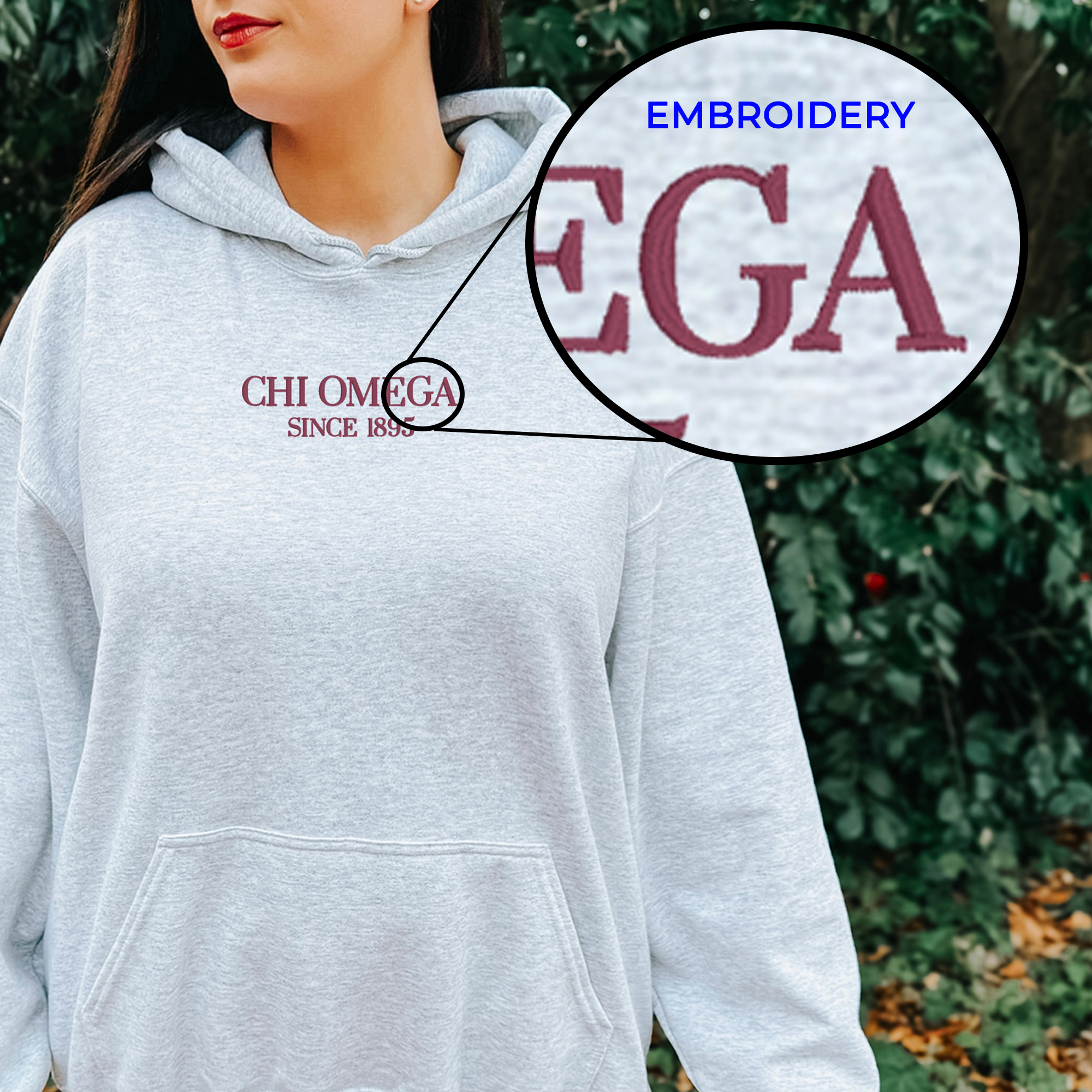 A woman wearing a grey hoodie with the text "CHI OMEGA SINCE 1855" embroidered on it.