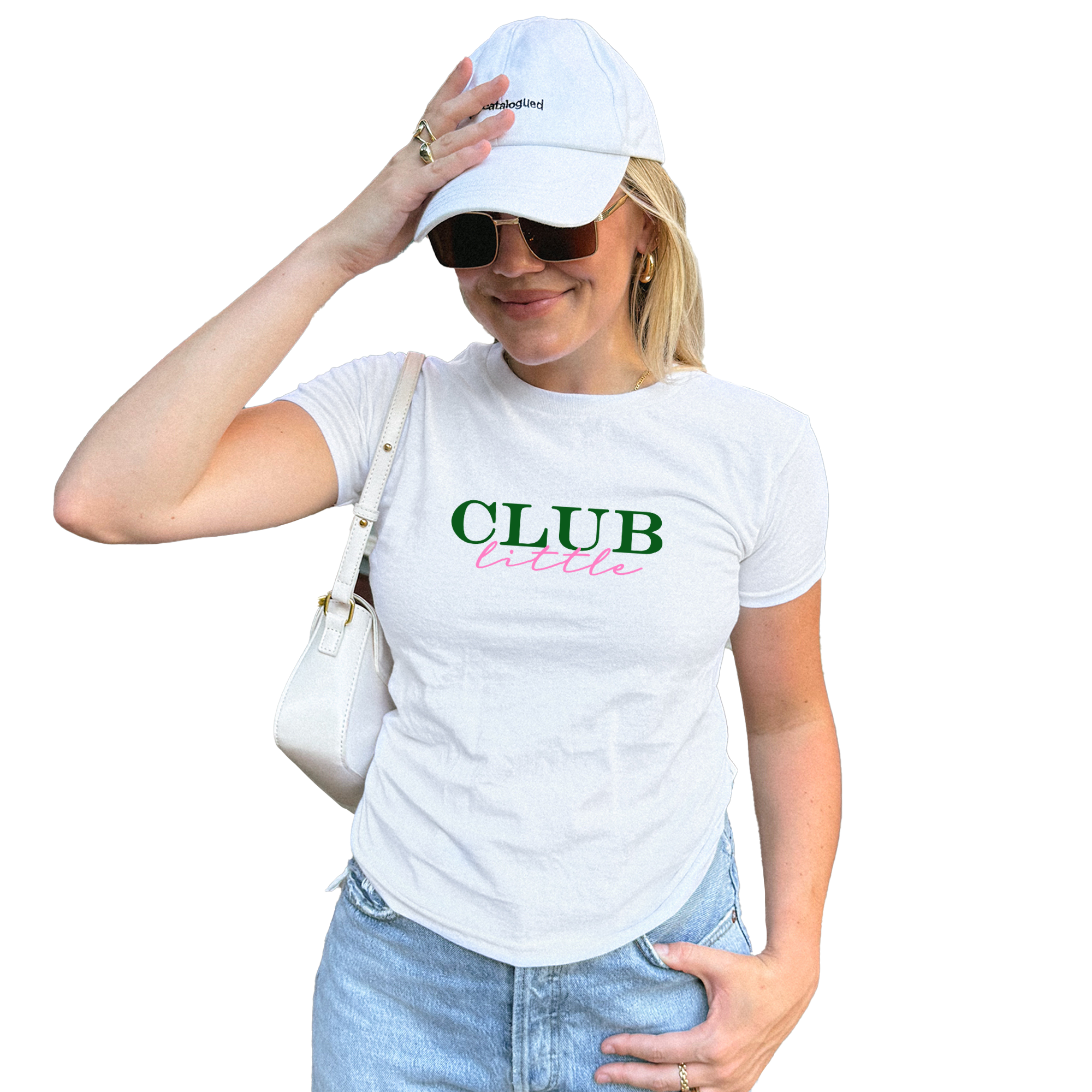 A woman wearing a white cap and sunglasses, with a white t-shirt that says "CLUB" in pink and green text. She is holding a white purse in her hand.