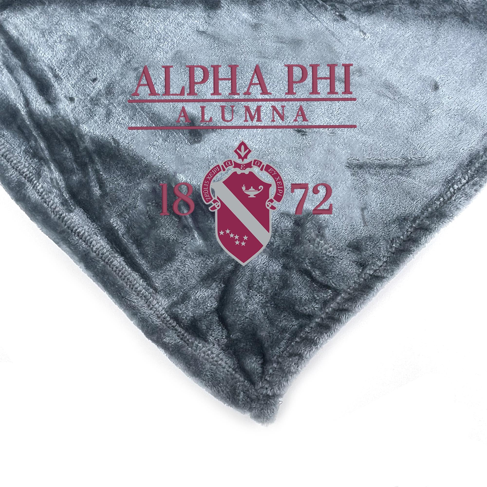 a gray fabric with the text "ALPHA PHI ALUMNA 18 72" printed on it, along with a red and white crest design.