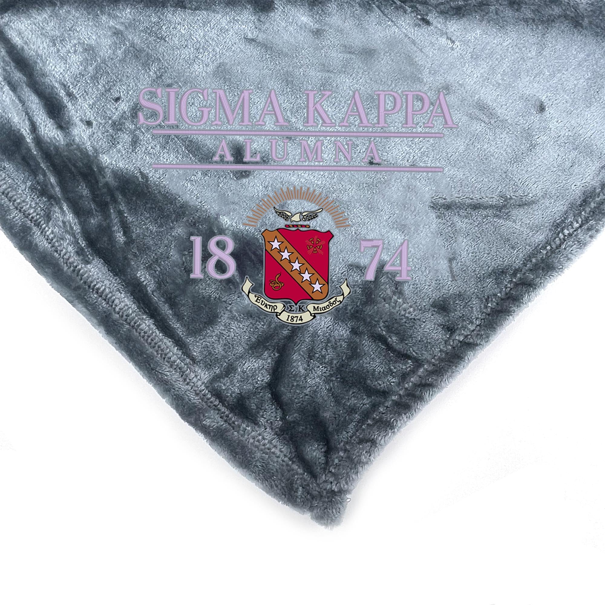 a gray fabric with the text "SIGMA-KAPPA ALUMNA 1874" and a crest design.