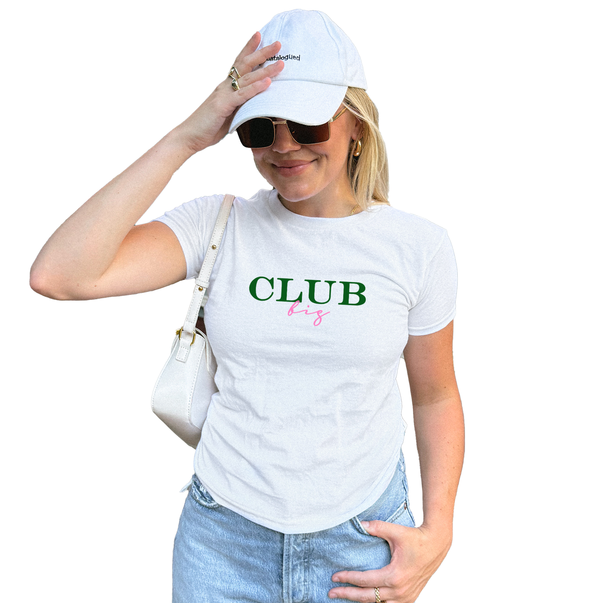 A woman wearing a white cap and sunglasses, with a white t-shirt that says "CLUB" in pink and green text. She is holding a white purse in her hand.