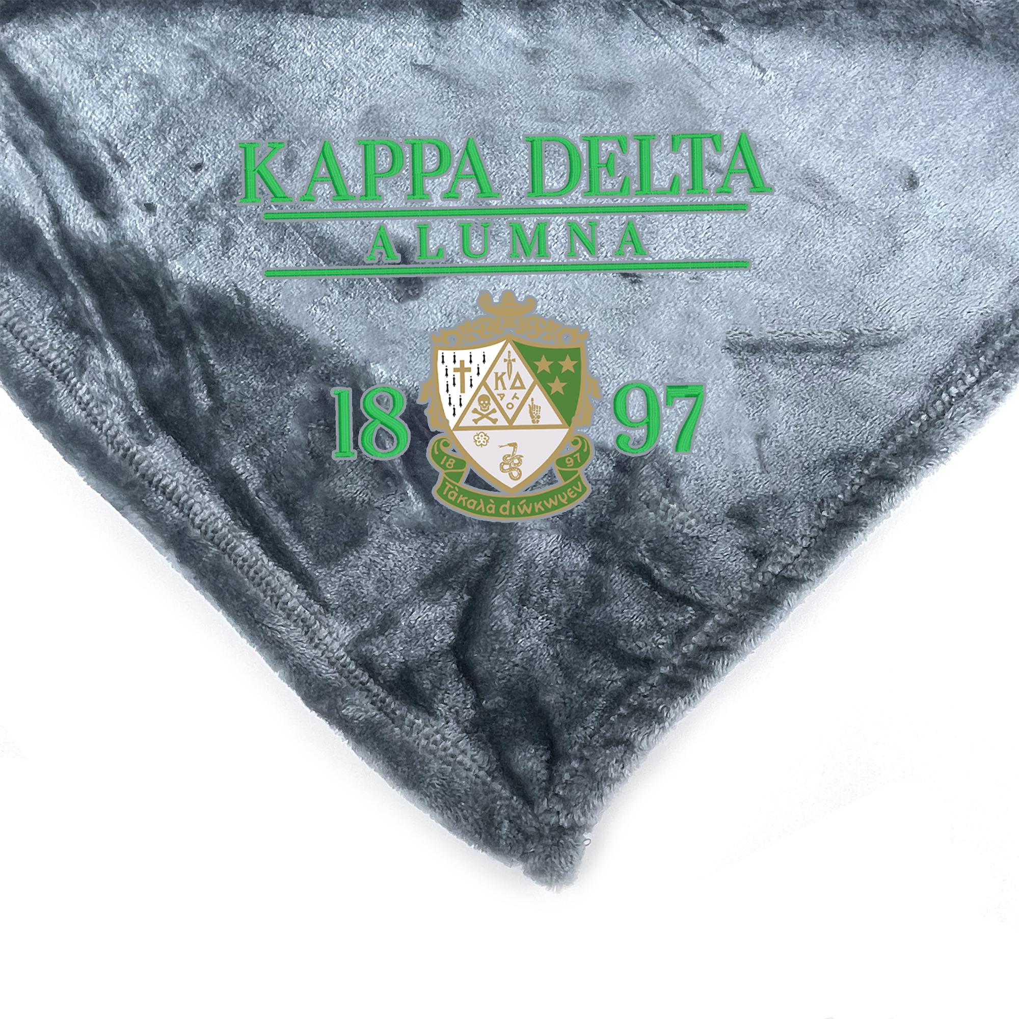 a gray fabric with green text and a crest design, which appears to be a blanket or throw.