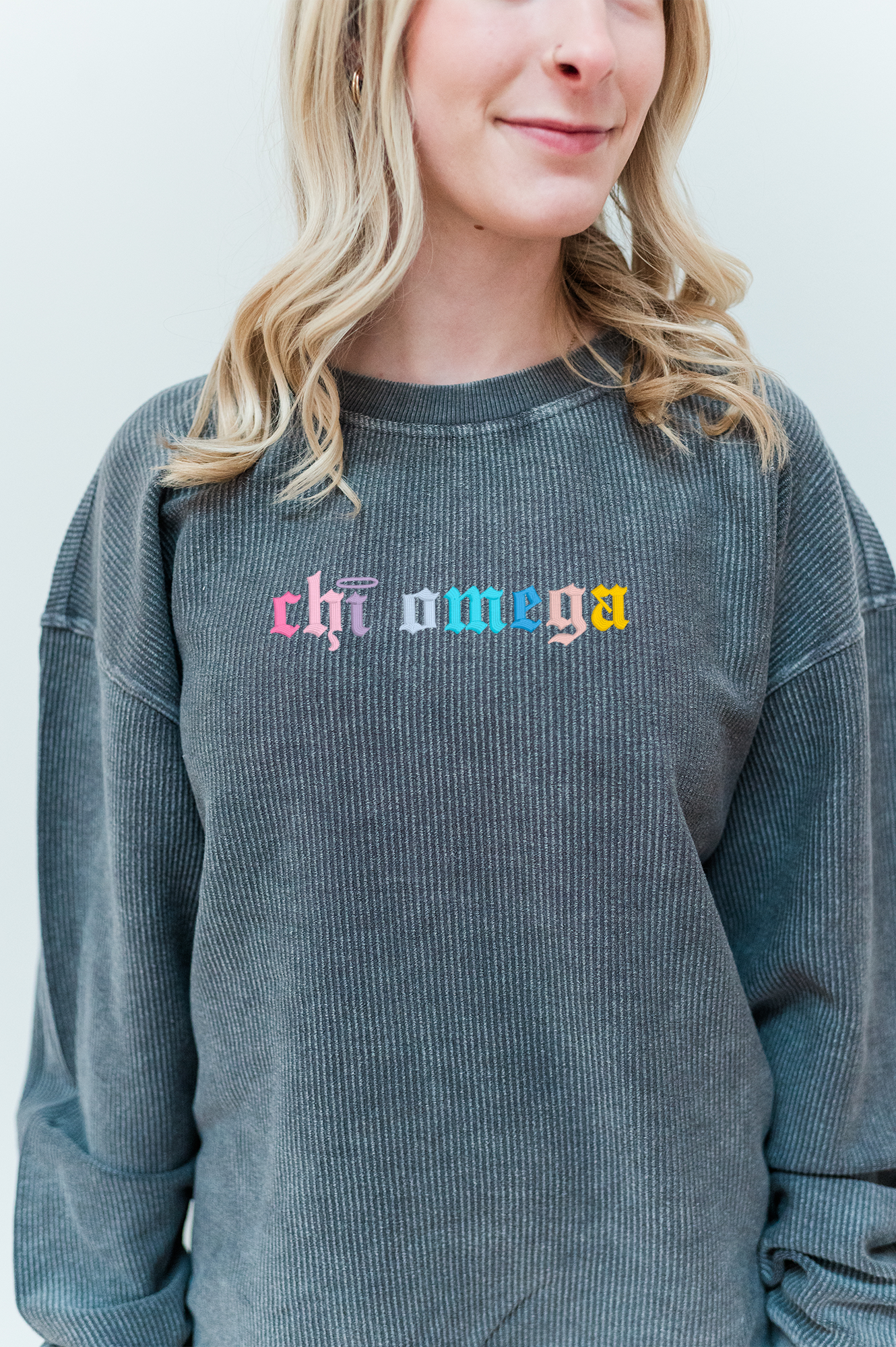 a woman with blonde hair wearing a gray sweater