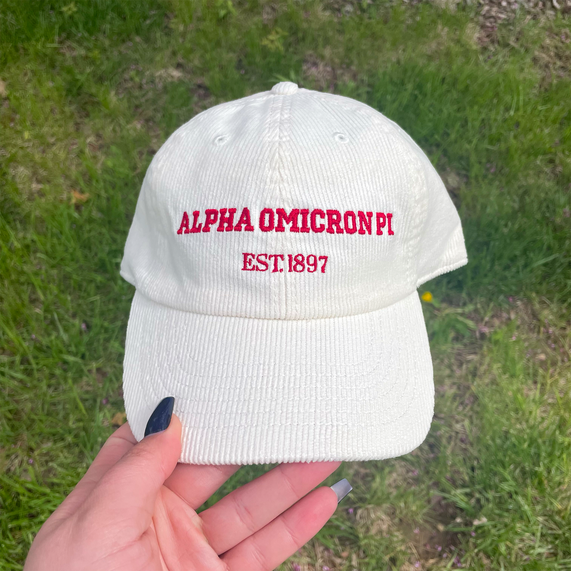 a person holding up a white hat with the word, alpha omcorni