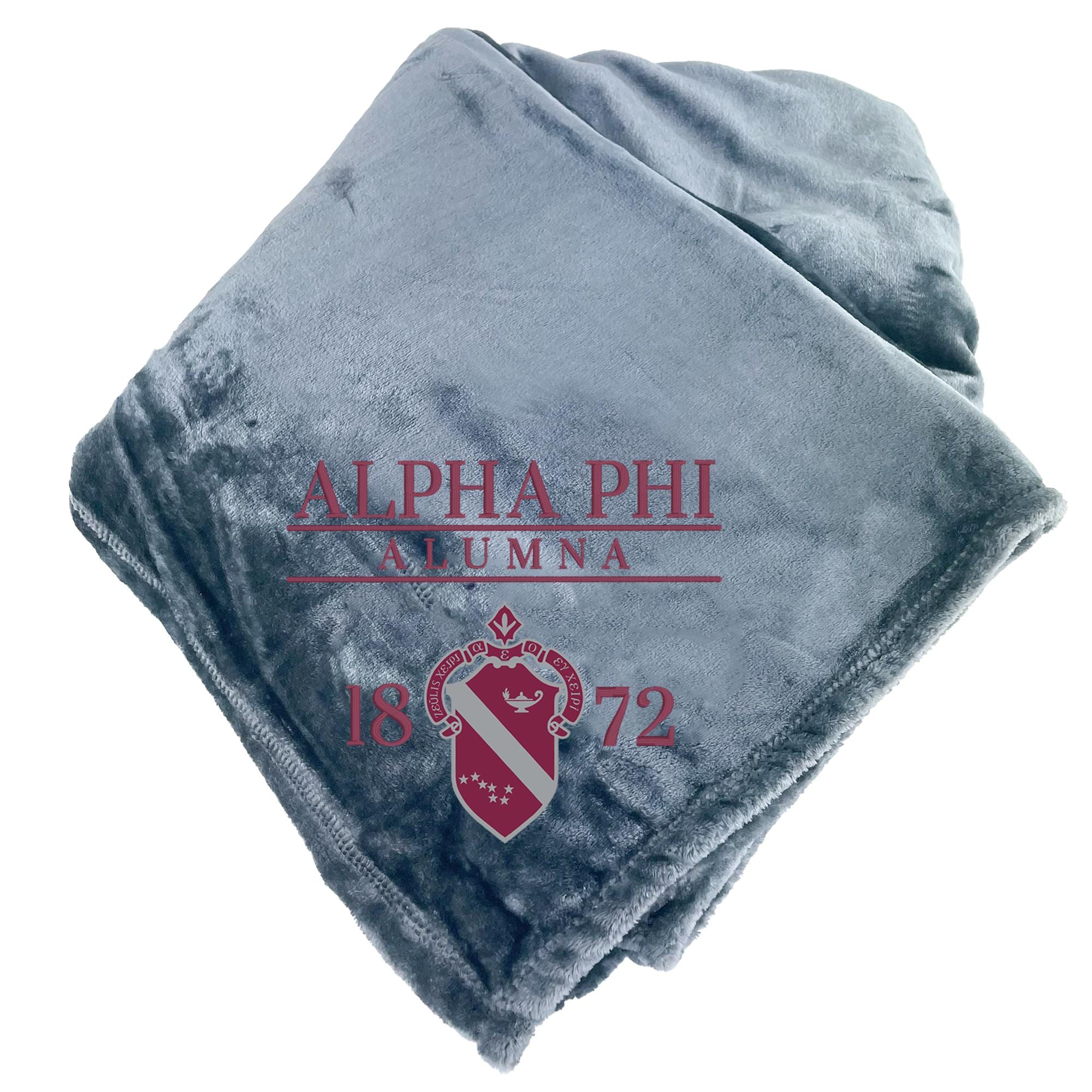 a gray blanket with the text "ALPHA PHI ALUMNA 1872" printed on it.