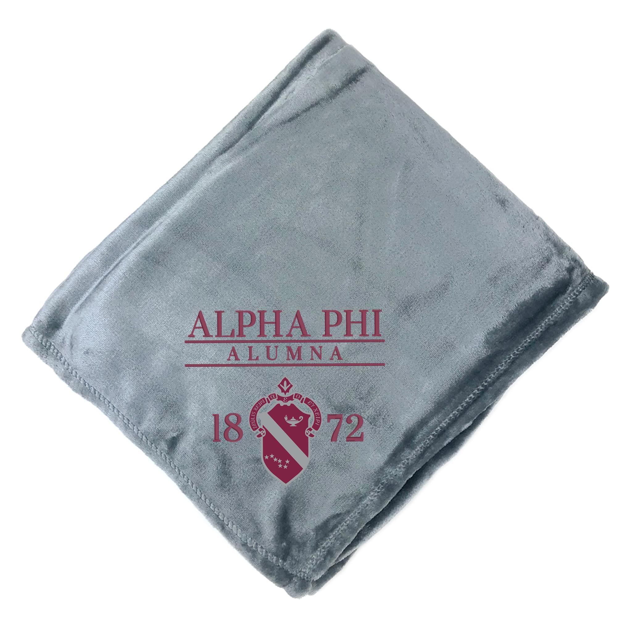 a gray blanket with the text "ALPHA PHI ALUMNA 1872" printed on it.
