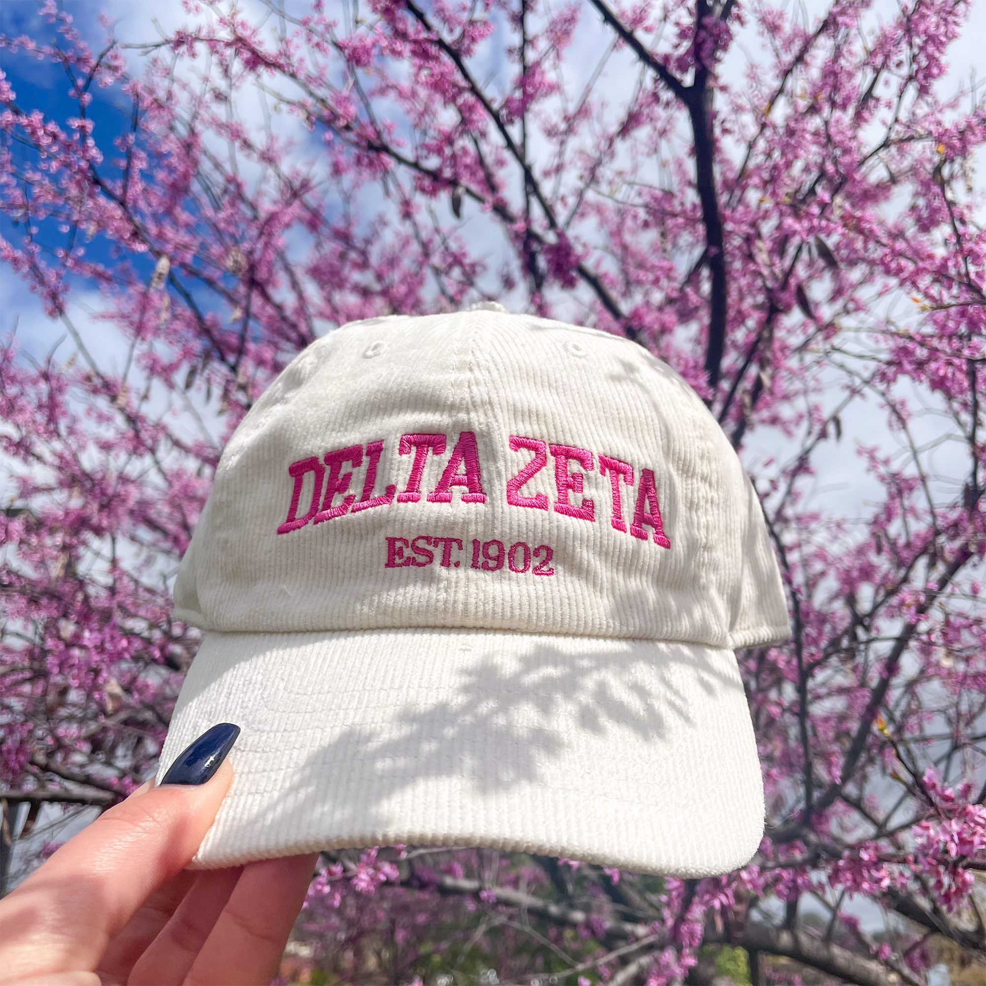 a white hat with the delta zeta embroidered on it