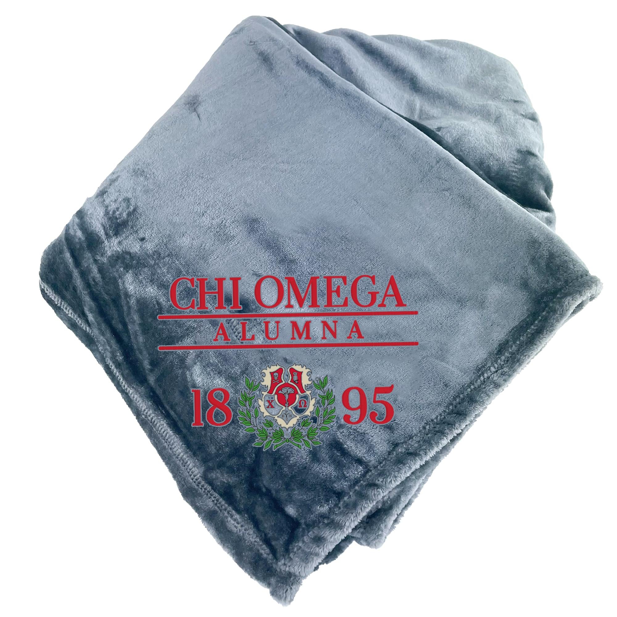 A gray fleece blanket with the text "CHI OMEGA AULNA 18 95" printed on it.